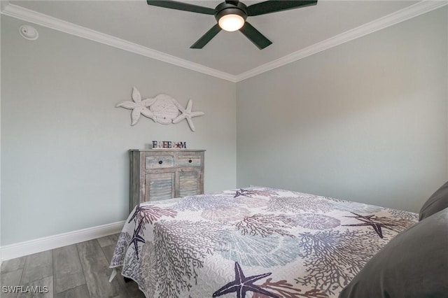 bedroom with baseboards, crown molding, a ceiling fan, and wood finished floors