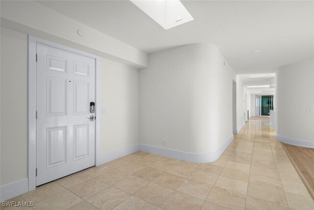 3127 W Gulf Dr Unit 106, Sanibel, FL 33957 - hall featuring light tile patterned flooring, a skylight, and baseboards