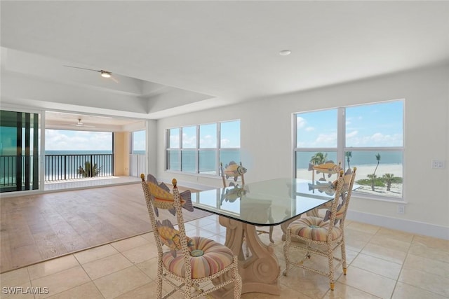 3127 W Gulf Dr Unit 106, Sanibel, FL 33957 - dining room with a tray ceiling, light tile patterned floors, and a healthy amount of sunlight