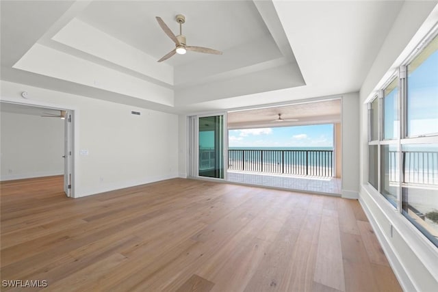 3127 W Gulf Dr Unit 106, Sanibel, FL 33957 - unfurnished room featuring baseboards, ceiling fan, light wood-style floors, and a raised ceiling