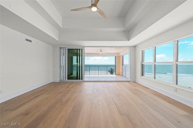 3127 W Gulf Dr Unit 106, Sanibel, FL 33957 - empty room with a tray ceiling, light wood-type flooring, baseboards, visible vents, and ceiling fan
