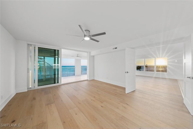 3127 W Gulf Dr Unit 106, Sanibel, FL 33957 - spare room featuring expansive windows, light wood-type flooring, baseboards, visible vents, and ceiling fan