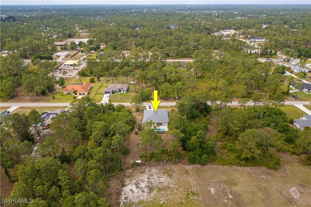 drone / aerial view with a forest view and a residential view