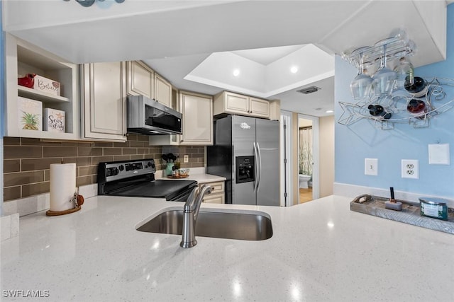 9623 Eaton Gardens Ln Unit 105, Fort Myers, FL 33919 - kitchen featuring stainless steel appliances, backsplash, cream cabinetry, a sink, and visible vents
