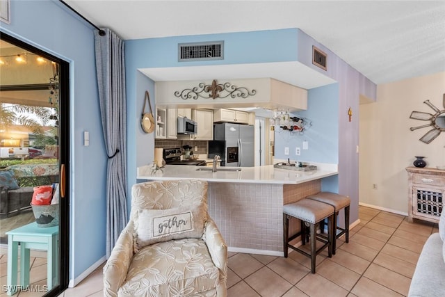 9623 Eaton Gardens Ln Unit 105, Fort Myers, FL 33919 - kitchen featuring a sink, visible vents, a kitchen breakfast bar, and appliances with stainless steel finishes