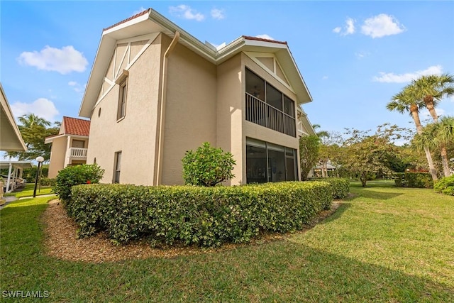 9623 Eaton Gardens Ln Unit 105, Fort Myers, FL 33919 - view of side of property featuring a tile roof, stucco siding, an attached garage, and a yard
