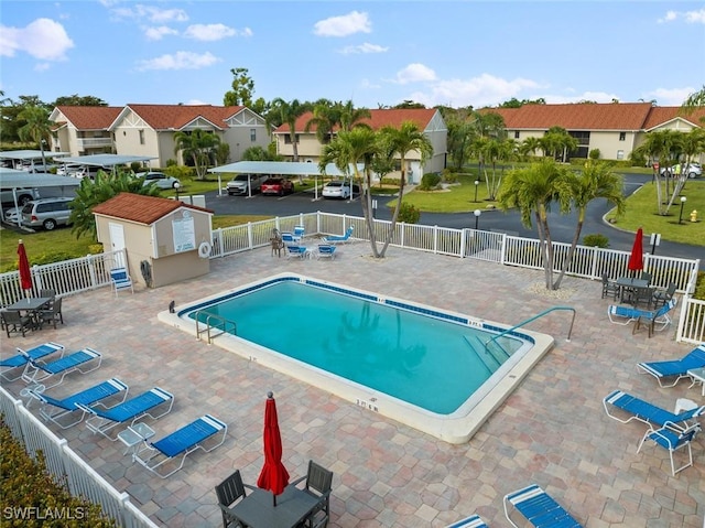 9623 Eaton Gardens Ln Unit 105, Fort Myers, FL 33919 - pool featuring a residential view, an outbuilding, fence, and a patio