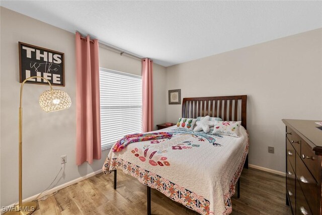 9623 Eaton Gardens Ln Unit 105, Fort Myers, FL 33919 - bedroom with baseboards and wood finished floors