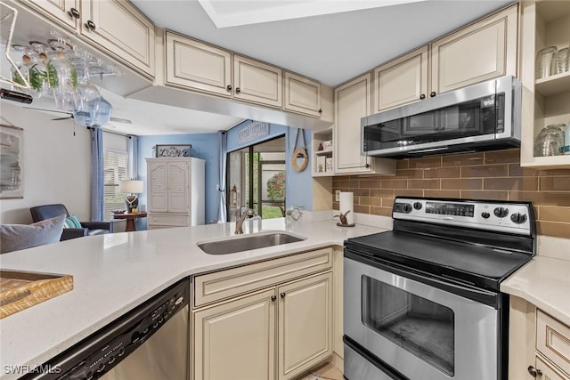 9623 Eaton Gardens Ln Unit 105, Fort Myers, FL 33919 - kitchen with light countertops, cream cabinetry, stainless steel appliances, tasteful backsplash, and a sink