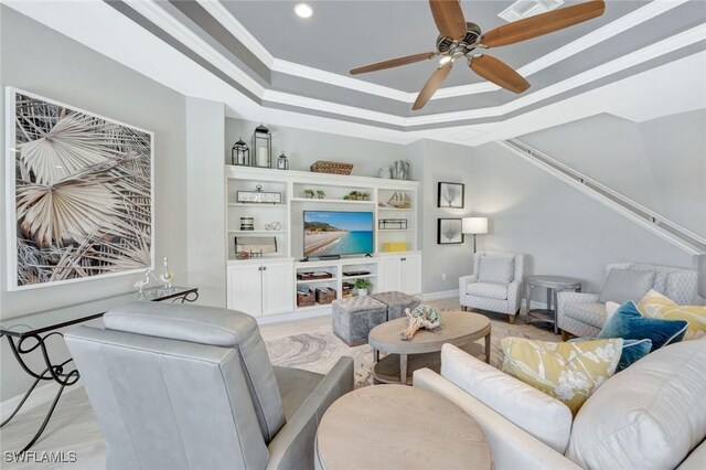 living room with a tray ceiling, ceiling fan, recessed lighting, and baseboards