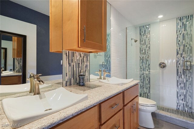 16860 Ginger Ln Unit 3049, Fort Myers, FL 33908 - bathroom featuring a stall shower, double vanity, toilet, and recessed lighting