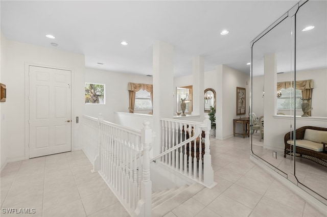 hallway with baseboards, recessed lighting, an upstairs landing, and light tile patterned floors