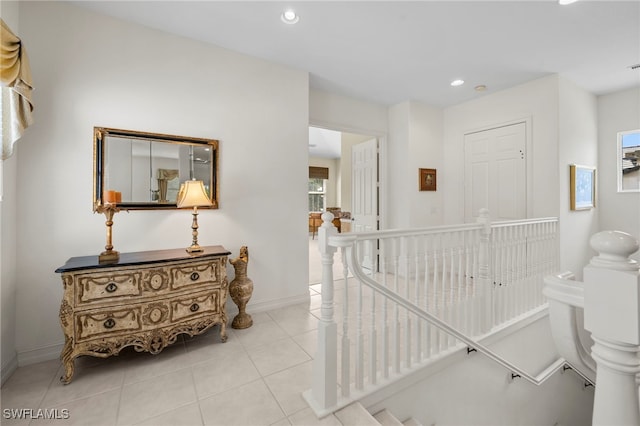 hall featuring recessed lighting, baseboards, light tile patterned flooring, and an upstairs landing
