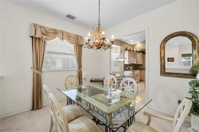 dining area featuring light colored carpet, an inviting chandelier, visible vents, and baseboards