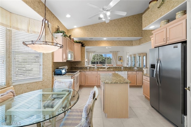 kitchen featuring light brown cabinetry, a ceiling fan, white appliances, a peninsula, and high vaulted ceiling