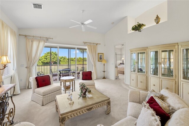 living area featuring lofted ceiling, a ceiling fan, visible vents, and light colored carpet