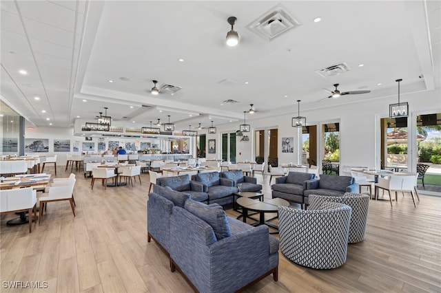 living area featuring ceiling fan, visible vents, and light wood-type flooring