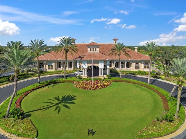 exterior space with a tile roof and curved driveway