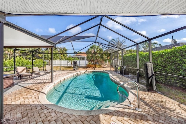 outdoor pool with fence, a patio, and a lanai