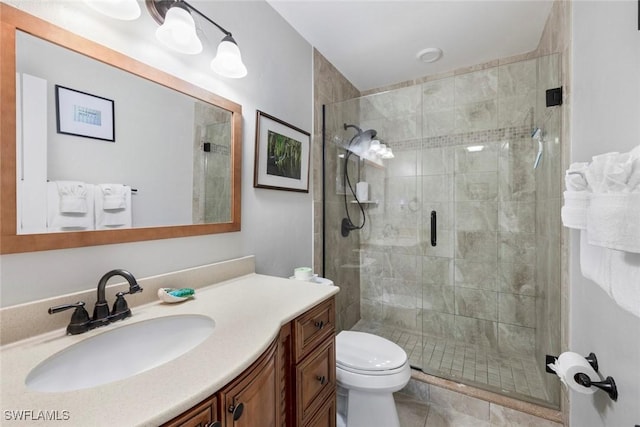 bathroom featuring a shower stall, vanity, and toilet