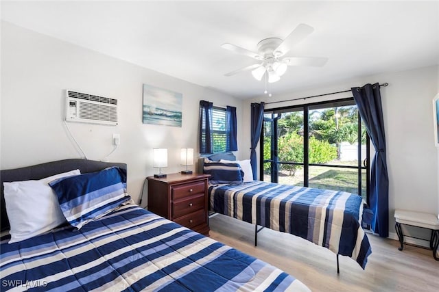 bedroom with an AC wall unit, light wood-style flooring, and ceiling fan