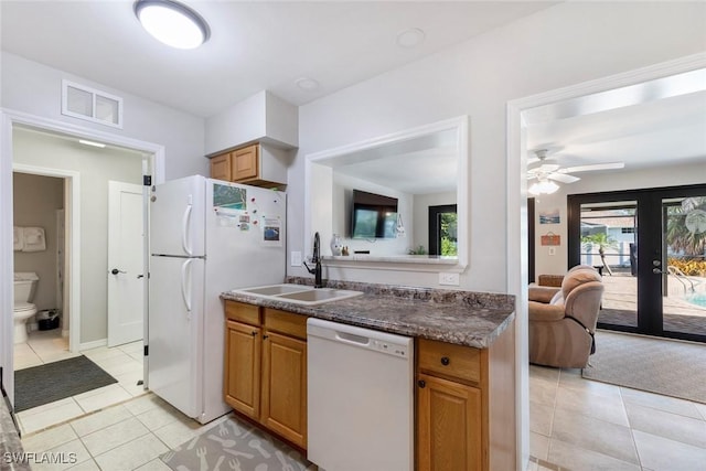 kitchen featuring visible vents, a sink, open floor plan, ceiling fan, and white appliances