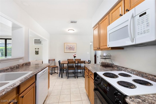 kitchen with white appliances, visible vents, light tile patterned flooring, dark countertops, and a wall mounted air conditioner