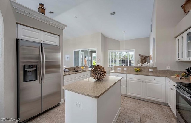 kitchen featuring visible vents, stainless steel fridge, a peninsula, a sink, and range with electric stovetop
