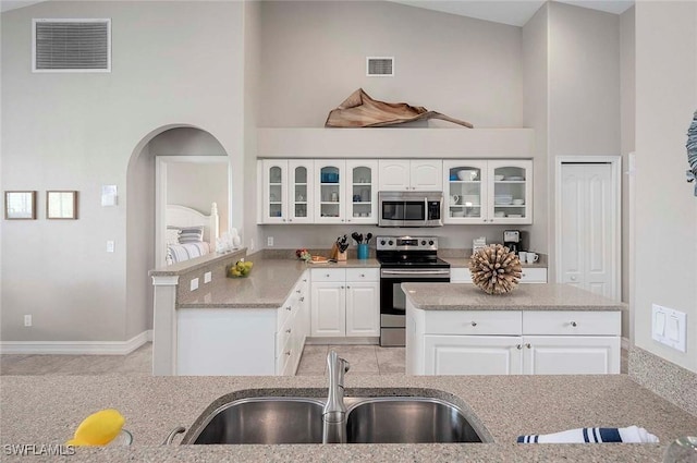 kitchen with a sink, high vaulted ceiling, visible vents, and appliances with stainless steel finishes