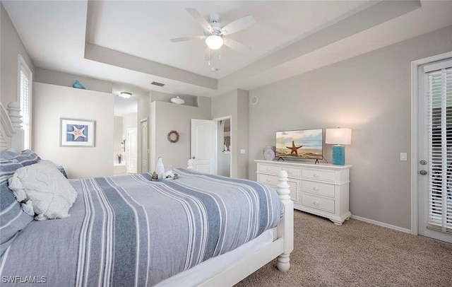 bedroom with visible vents, baseboards, connected bathroom, light carpet, and a tray ceiling