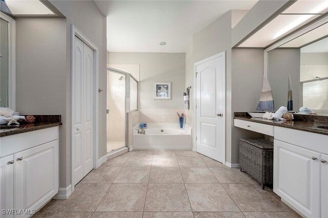 full bathroom with tile patterned floors, vanity, a garden tub, and a shower stall