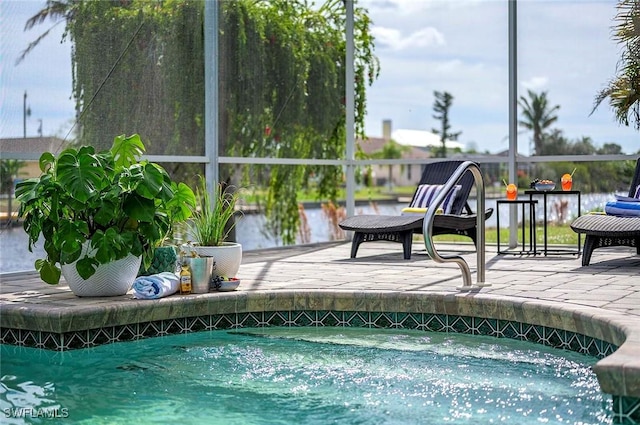 pool with a lanai, a patio, and a hot tub