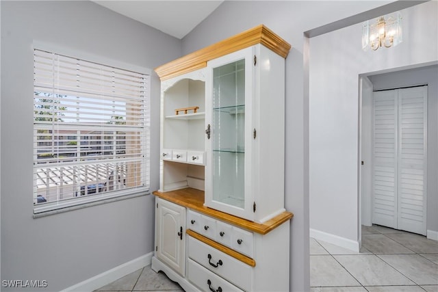 mudroom featuring baseboards, an inviting chandelier, and light tile patterned floors