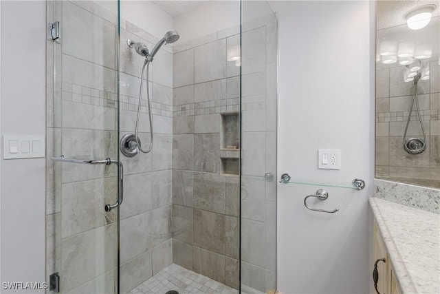 bathroom with a stall shower and vanity