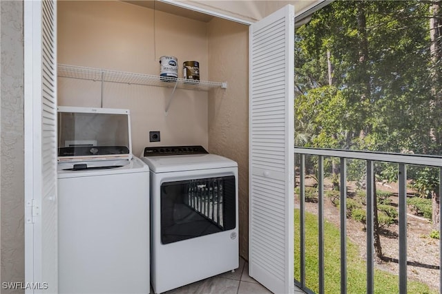 laundry area with washing machine and clothes dryer, tile patterned flooring, and laundry area