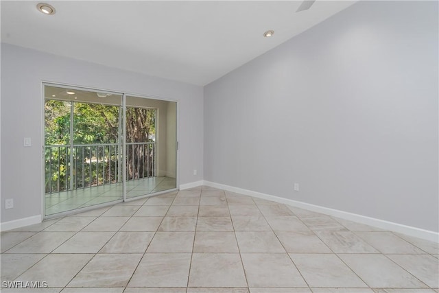 unfurnished room with baseboards, lofted ceiling, and light tile patterned floors