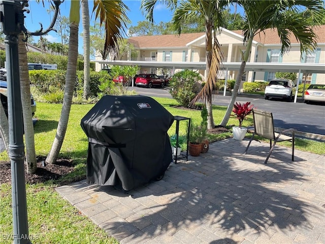 surrounding community with covered parking and a lawn