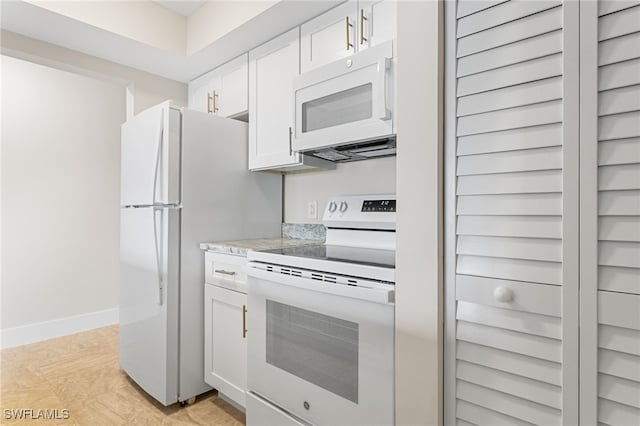 kitchen with white cabinets, baseboards, and white appliances
