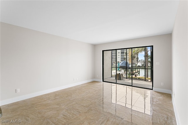 empty room featuring baseboards and marble finish floor