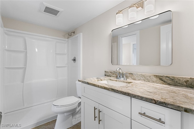 full bathroom featuring visible vents, toilet, vanity, and walk in shower