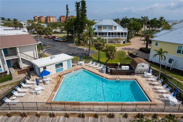 community pool with a patio and fence