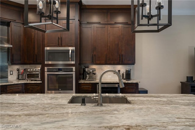 2613 Stonyhill Ct, Cape Coral, FL 33991 - kitchen with dark brown cabinets, an inviting chandelier, a sink, backsplash, and stainless steel appliances