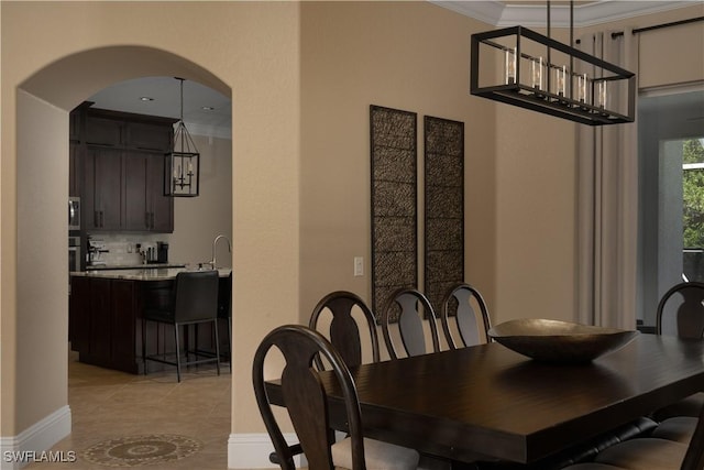 2613 Stonyhill Ct, Cape Coral, FL 33991 - dining area with crown molding, arched walkways, baseboards, and light tile patterned floors