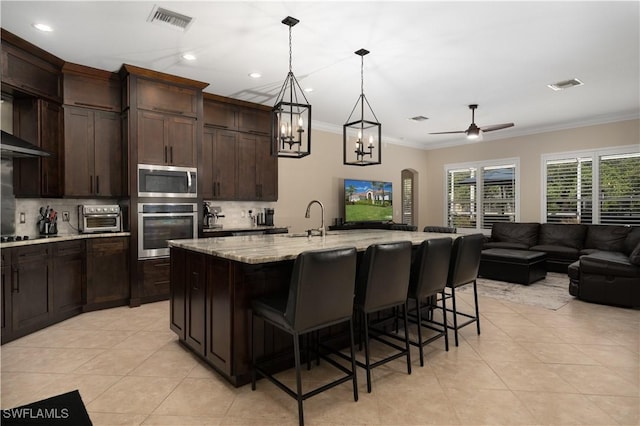 2613 Stonyhill Ct, Cape Coral, FL 33991 - kitchen featuring light tile patterned floors, crown molding, stainless steel appliances, and visible vents
