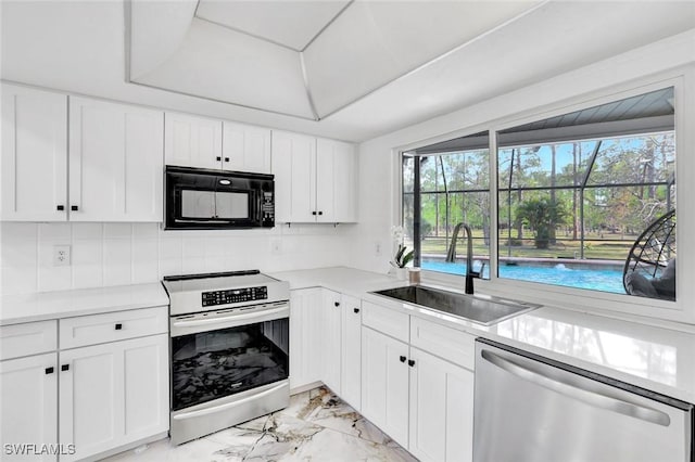 4500 1st Ave NW, Naples, FL 34119 - kitchen featuring light countertops, backsplash, stainless steel appliances, marble finish floor, and a sink