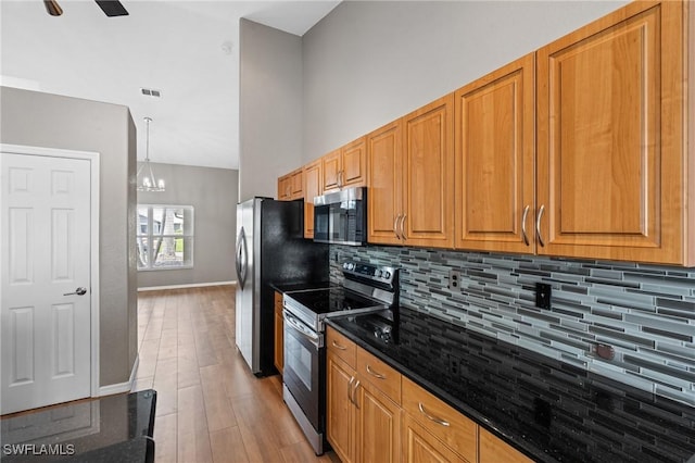 1703 SW 6th Ave, Cape Coral, FL 33991 - kitchen with appliances with stainless steel finishes, decorative backsplash, light wood-type flooring, and dark stone countertops