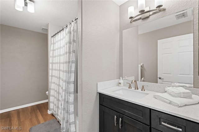 1703 SW 6th Ave, Cape Coral, FL 33991 - full bath with vanity, wood finished floors, toilet, baseboards, and curtained shower