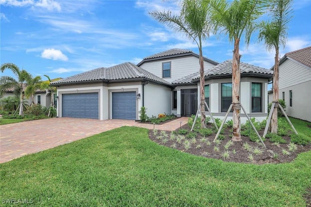 view of front facade featuring driveway, stucco siding, an attached garage, a front lawn, and a tiled roof