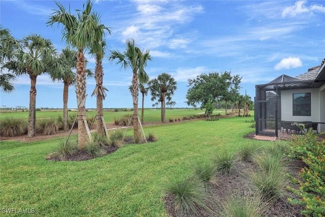 view of yard with glass enclosure and a rural view