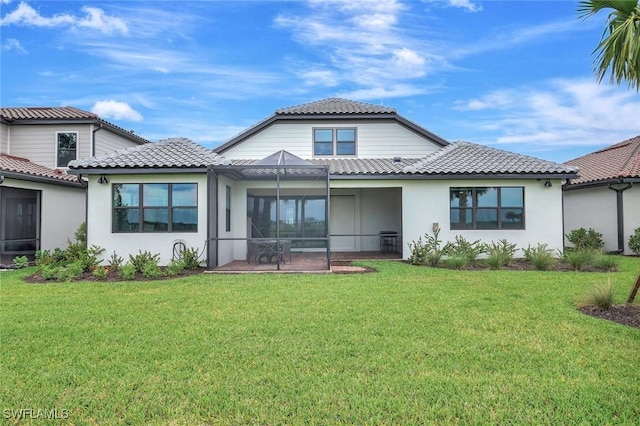 back of house featuring glass enclosure, a lawn, a tile roof, and stucco siding